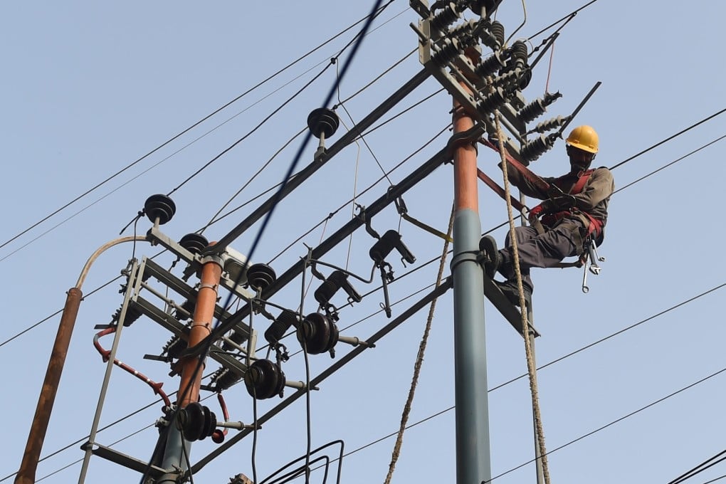 Karachi Electric Corporation technicians work on a high voltage line in Pakistan. Photo: AFP