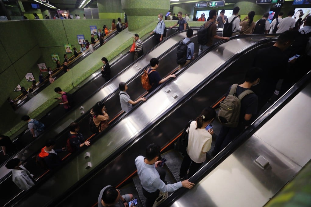 Commuters hold on to escalator handrails, or their phones, in Wan Chai MTR station on November 14. Photo: Sun Yeung