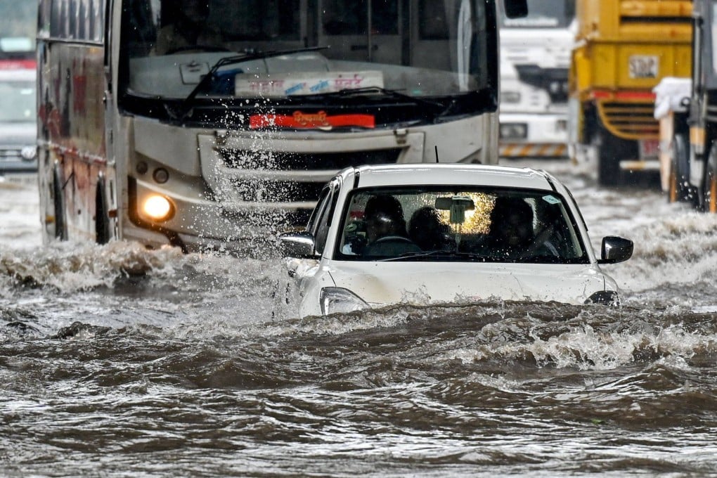A car lies partially submerged as it wades through a flooded street after heavy rain showers in Mumbai on May 26. Photo: AFP