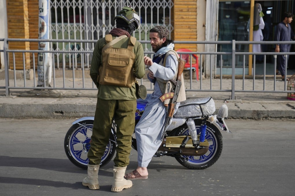 A Taliban fighter stops a man carrying a gun to check his documents during the Eid al-Adha prayer in Kabul, Afghanistan, on Saturday. Photo: AP