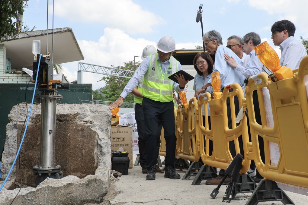 Government officials visit workers checking water pipes. The city has about 700km of pipes lined with bitumen. Photo: Edmond So