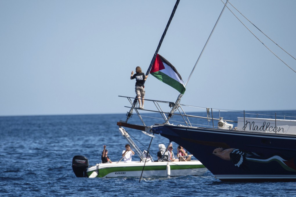 Climate activist Greta Thunberg stands near a Palestinian flag after boarding the Madleen boat and before setting sail for Gaza along with activists of the Freedom Flotilla Coalition, departing from the Sicilian port of Catania, Italy, on June 1. Photo: AP