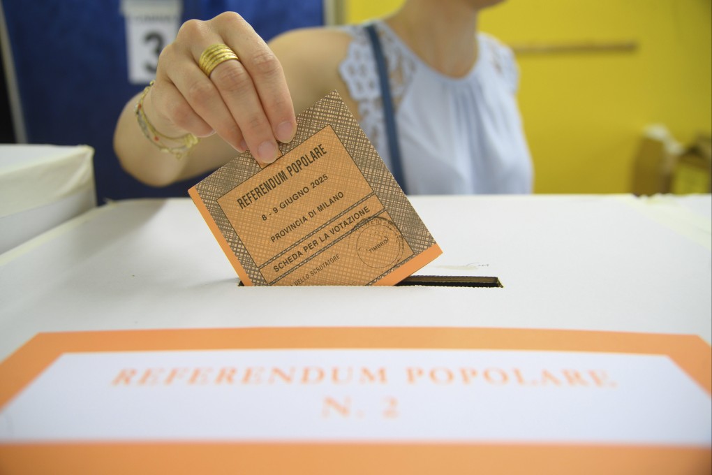 A woman casts her ballot in a box for referendums on citizenship and job protections, at a polling station in Milan, Italy, on Sunday. Photo: AP