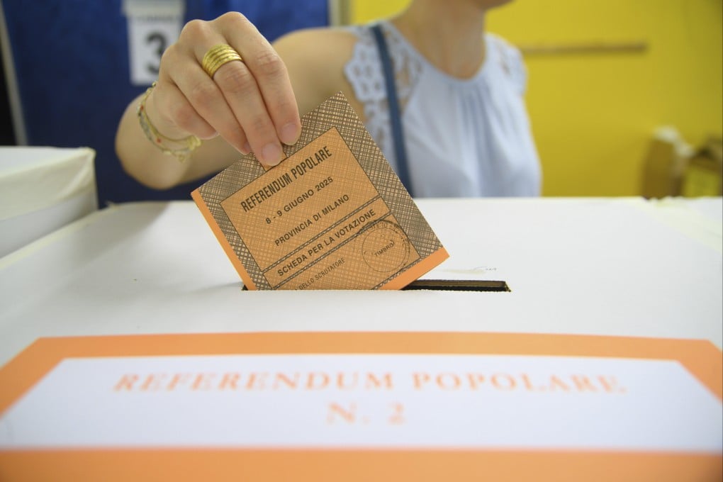 A woman casts her ballot in a box for referendums on citizenship and job protections, at a polling station in Milan, Italy, on Sunday. Photo: AP