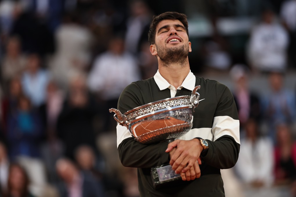 Carlos Alcaraz holds the trophy close after defending his French Open title in an epic five-set battle with Jannik Sinner. Photo: Xinhua