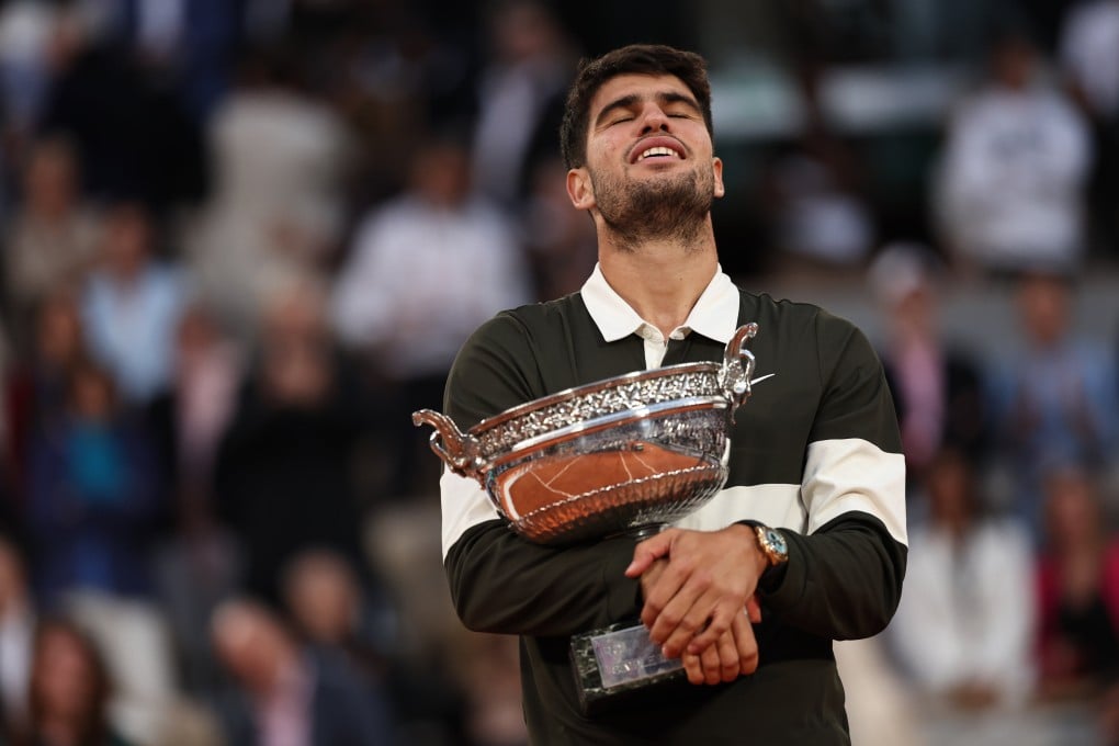 Carlos Alcaraz holds the trophy close after defending his French Open title in an epic five-set battle with Jannik Sinner. Photo: Xinhua