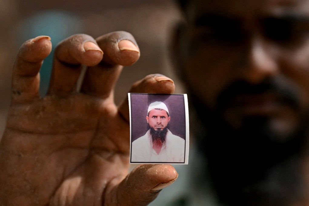 Shaikh Imran shows a photo of his brother Shaikh Latif Sheru, a farmer who committed suicide due to mounting financial loans. Photo: AFP