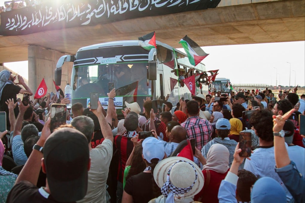 People cheer as a convoy of buses made up of activists, lawyers and medical professionals from North Africa depart from Tunisia to Gaza. Photo: AP