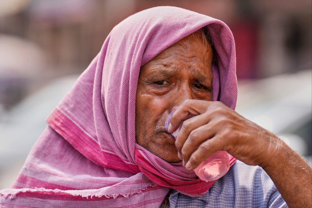 A passenger traveling in a vehicle stops for a free roadside drink on a hot summer day in Prayagraj in the northern state of Uttar Pradesh, India on Tuesday. Photo: AP