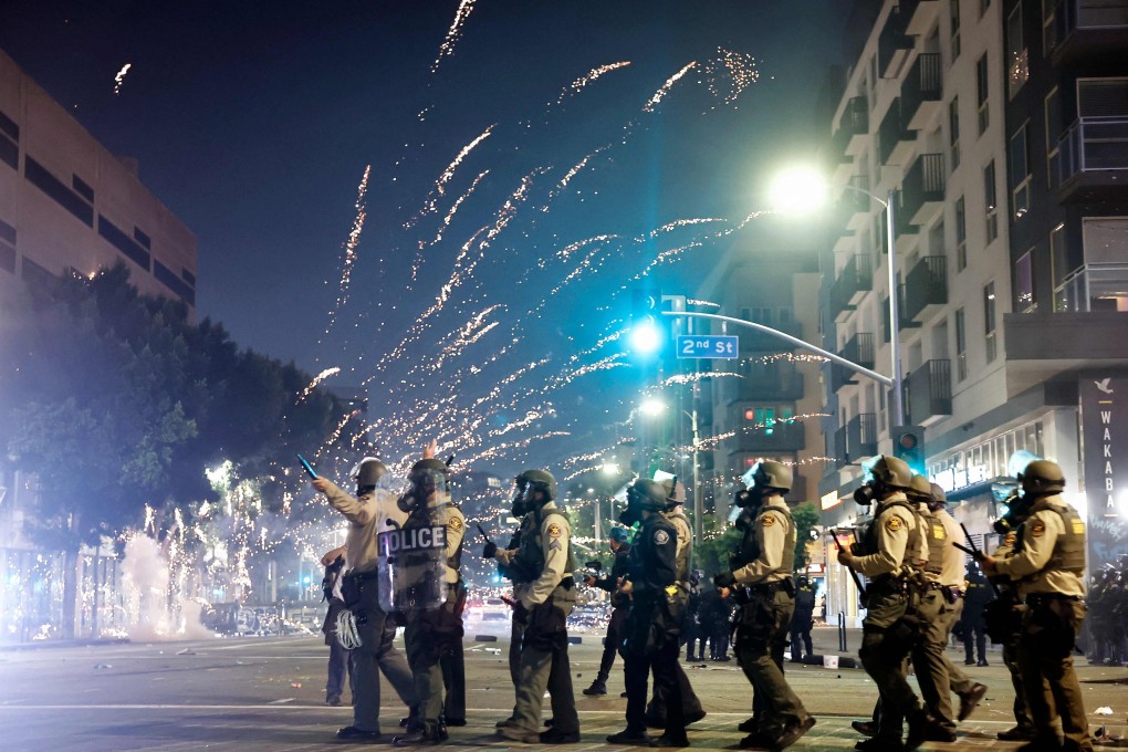 A firework explodes near police patrolling as protests continue in Los Angeles on June 9. Photo: Getty Images via AFP