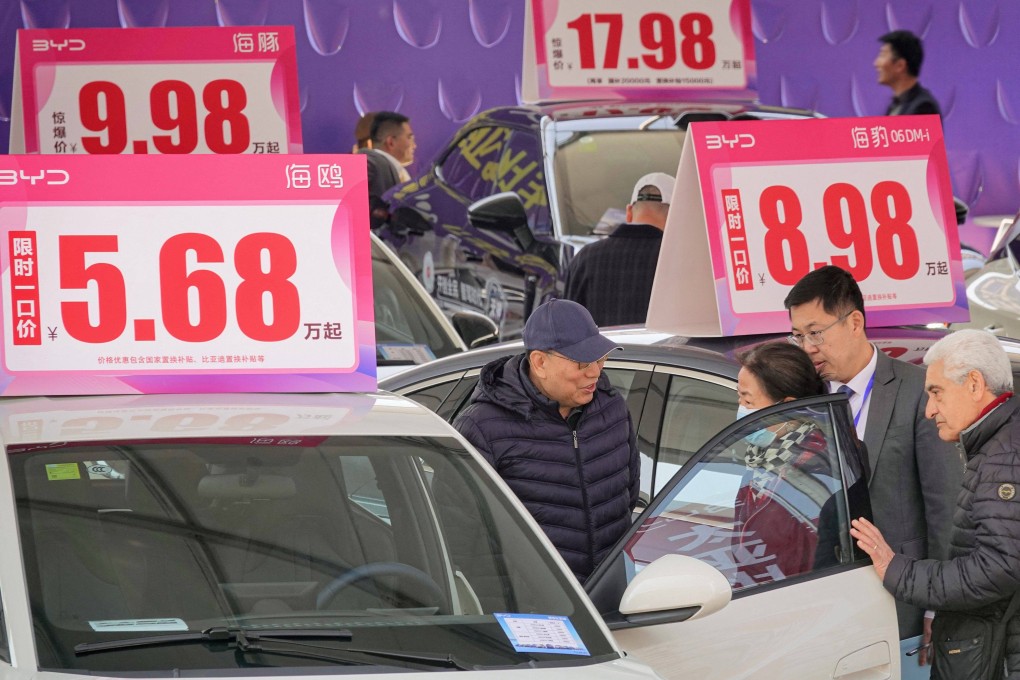Customers look at BYD cars at an auto show in Yantai, China. Photo: AFP