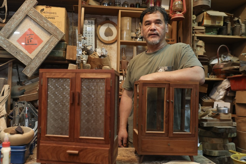 Timber artisan Lam Che stands with some of his furniture pieces at his workshop in Kwun Tong, Hong Kong, on June 4, 2025. Lam uses wood salvaged from fallen trees to make furniture including stools and tabletop accessories such as radio and jewellery cabinets. Photo: Edmond So