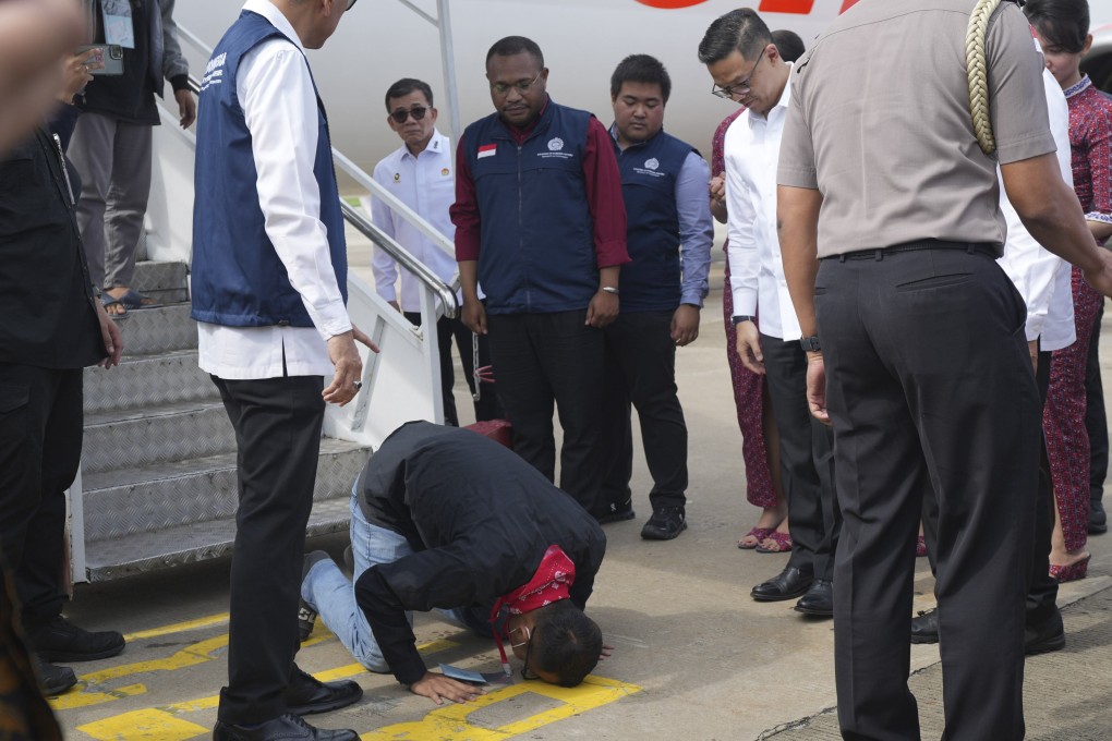 An Indonesian national rescued from Myanmar kisses the ground upon arrival at Soekarno-Hatta airport near Jakarta on March 18. Southeast Asian scam centres involve criminal gangs trafficking hundreds of thousands of people to help generate illicit revenues. Photo: AP