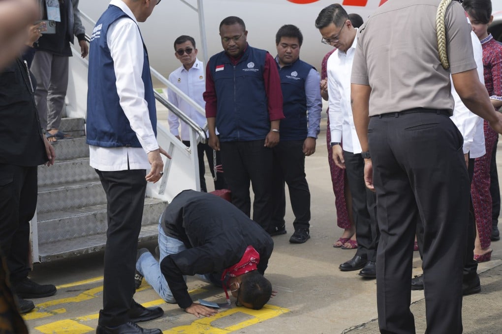 An Indonesian national rescued from Myanmar kisses the ground upon arrival at Soekarno-Hatta airport near Jakarta on March 18. Southeast Asian scam centres involve criminal gangs trafficking hundreds of thousands of people to help generate illicit revenues. Photo: AP