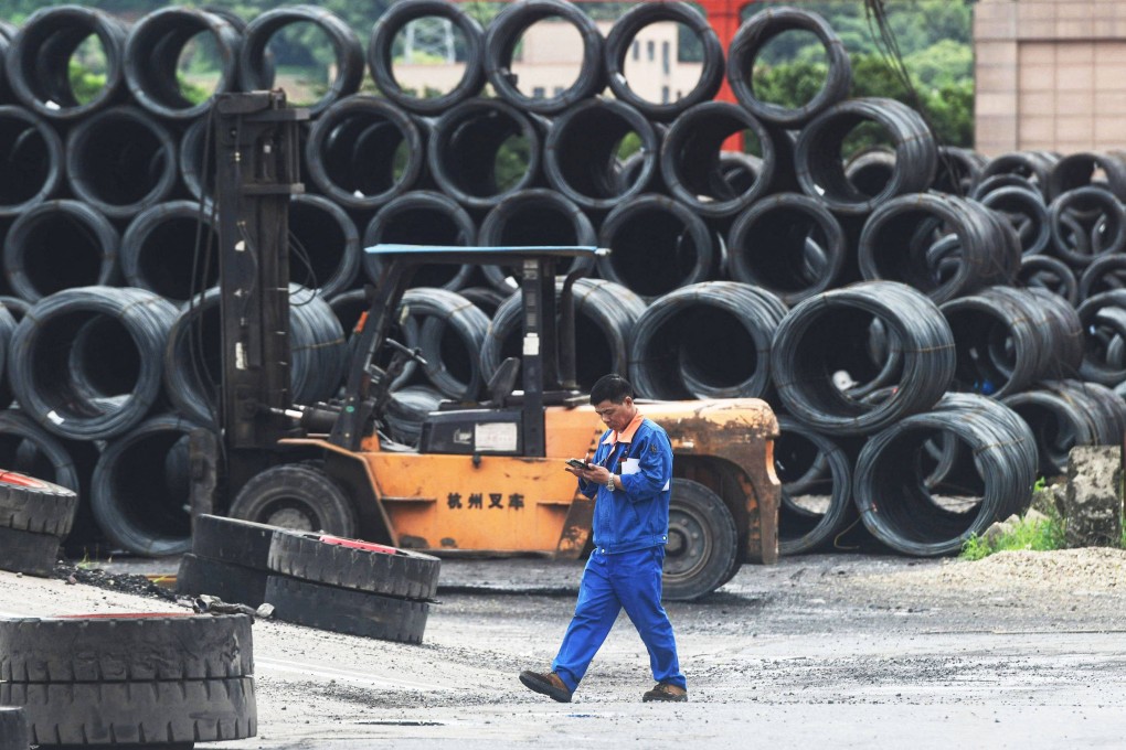 A worker walks past rolls of steel at a steel market in Hangzhou, Zhejiang province, on Wednesday. Photo: AFP