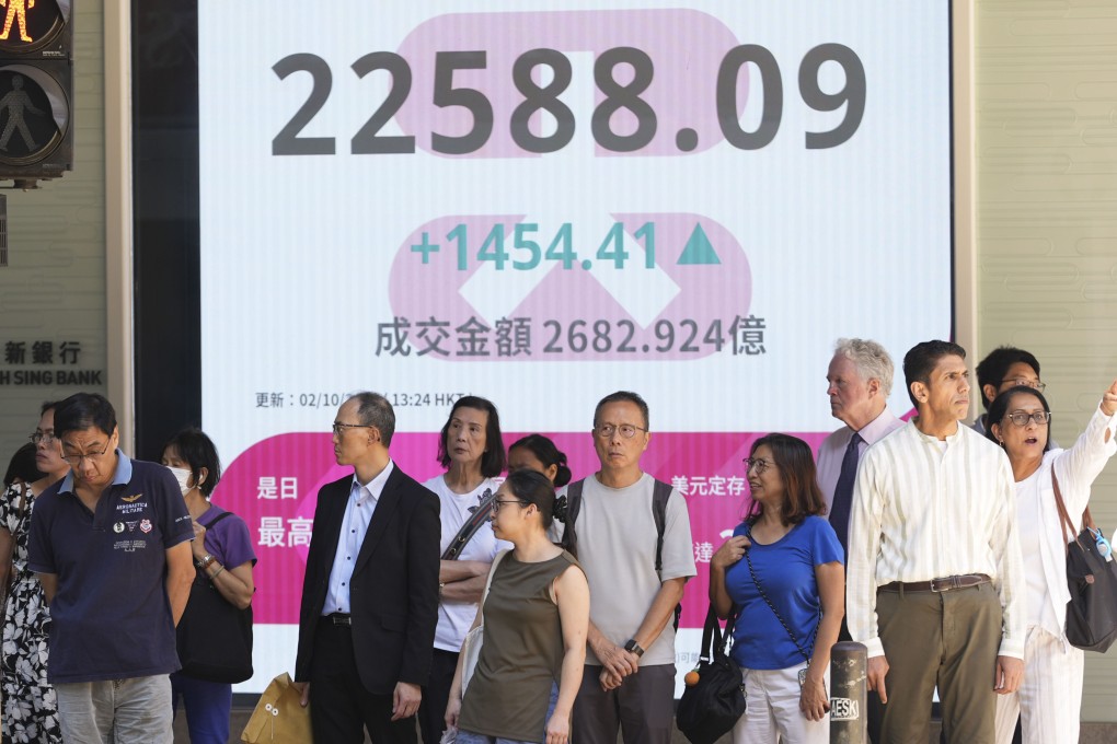 People in Central district stand near a screen displaying stock data on October 2. Photo: Eugene Lee