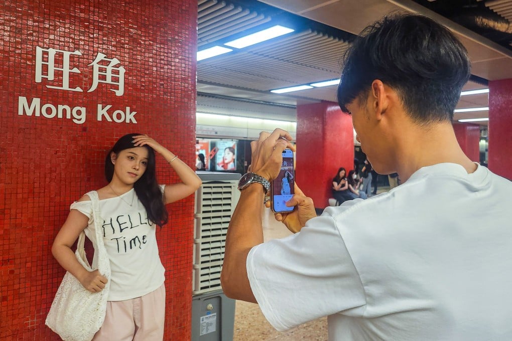 A mainland visitor poses next to the Mong Kok MTR station sign. The station and the Tsim Sha Tsui one are particularly popular with tourists from across the border. Photo: Timon Johnson