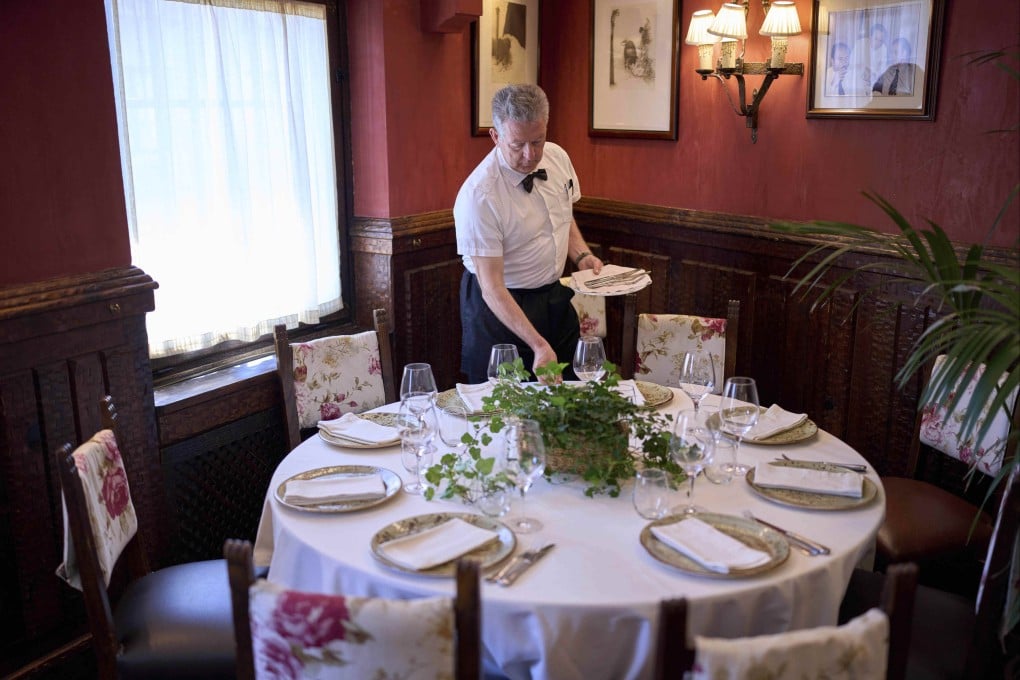 A waiter sets a table at Casa Pedro. The owners of the restaurant, in Fuencarral, Madrid, have hired a historian to prove their restaurant opened in 1702 – which would make it older than the current record holder across town. Photo: AP