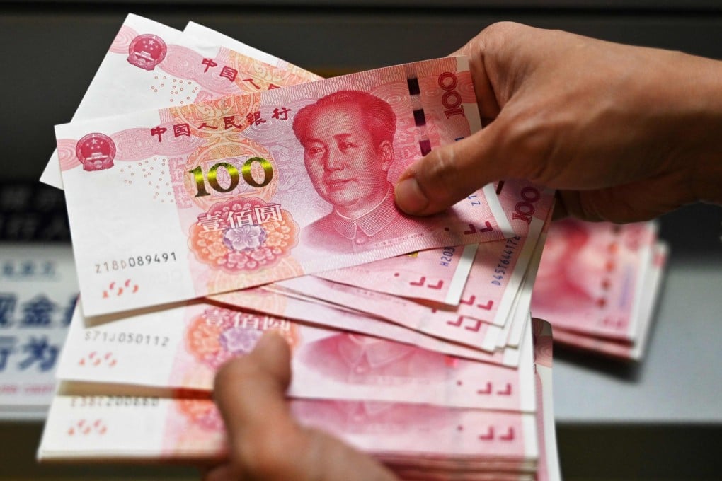 An employee counts 100-yuan notes at a bank in Beijing on November 14, 2024. Photo: AFP