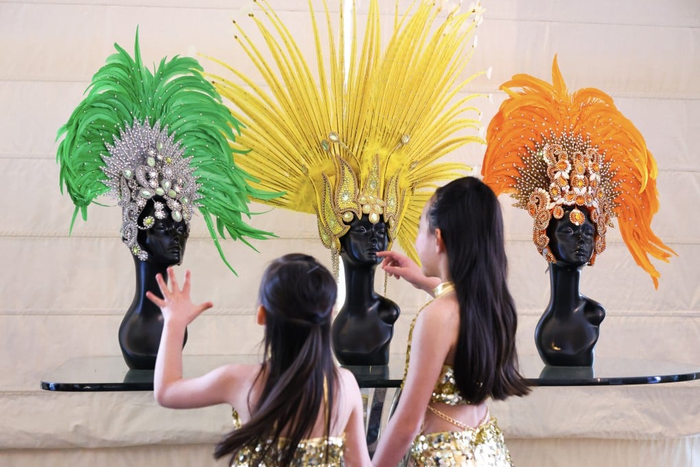 Young students of the SDM dance school admire extravagant samba headdresses for Hong Kong’s Brazilian festival, which comes to the city for 10 days from June 20-29. Photo: Nora Tam