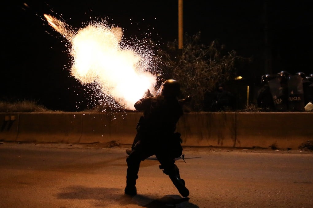 A Bolivian police officer tear gas during a confrontation with supporters of former president Evo Morales in Vinto, Bolivia. Photo: EPA-EFE