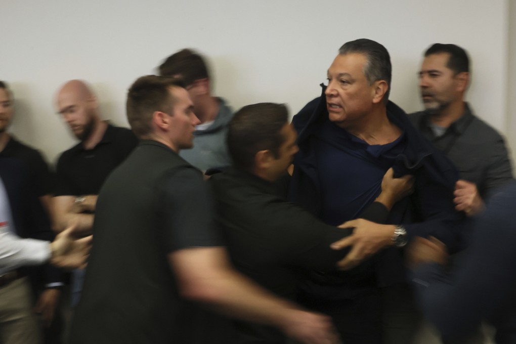US Senator Alex Padilla being pushed out of the room as Homeland Security Secretary Kristi Noem holds a news conference. Photo: AP