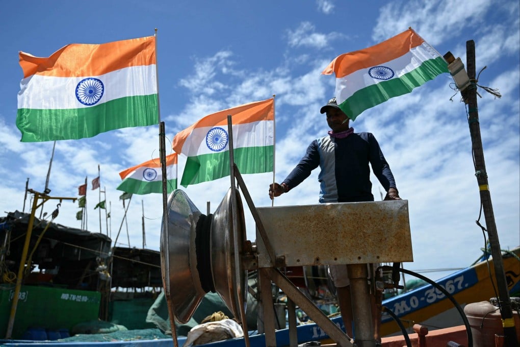 A fisherman places India’s national flags on his boat as he prepares for a boat rally to express solidarity with the Indian armed forces at the Kasimedu fishing harbour in Chennai on May 25. Photo: AFP