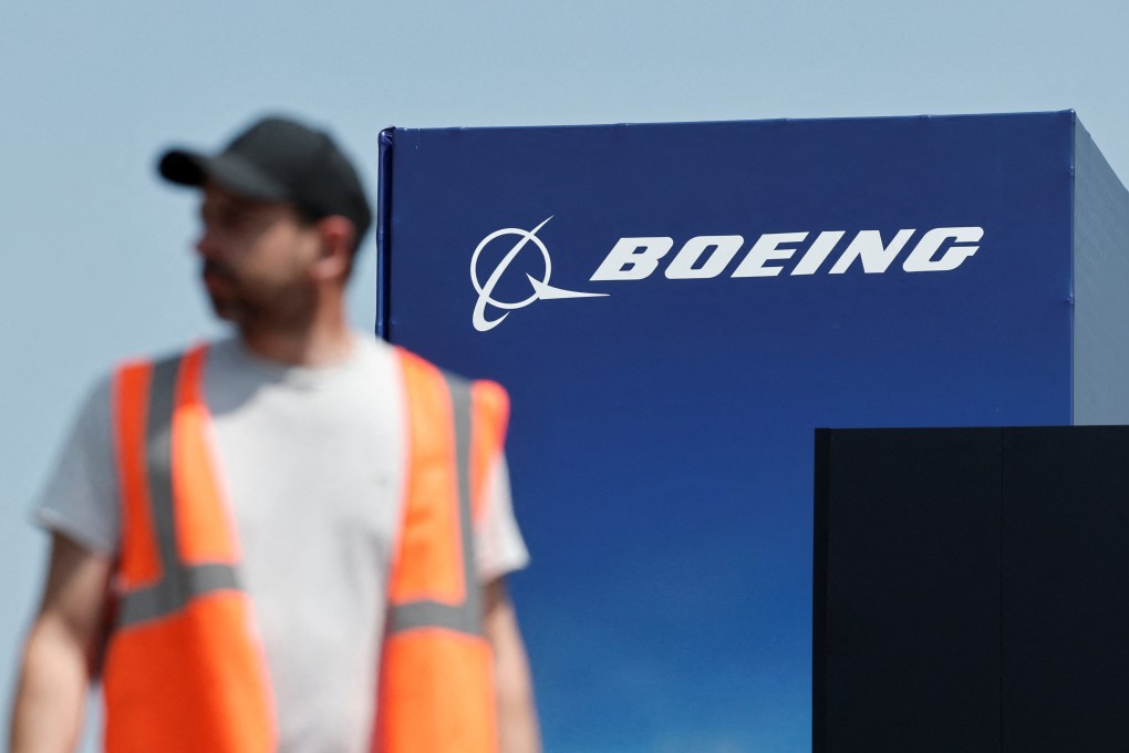 A worker walks past a Boeing logo before the opening of the 55th International Paris Airshow on Friday. Photo: Reuters