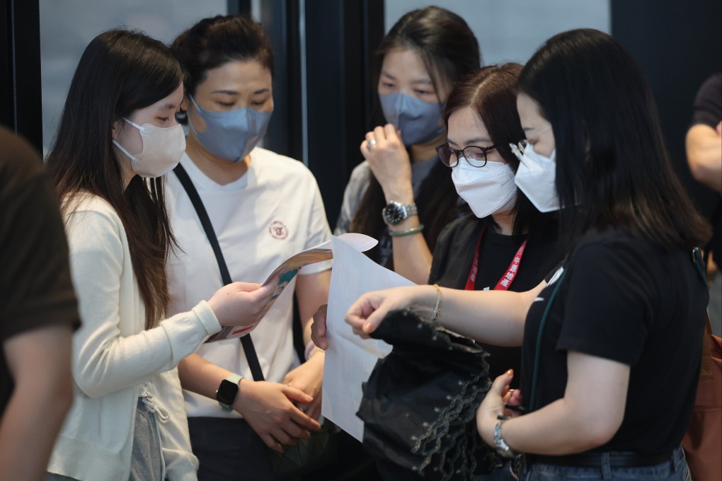 Prospective homebuyers huddle outside the sales office of Deep Water Pavilia at K11 Atelier in Quarry Bay on Saturday. Photo: Edmond So