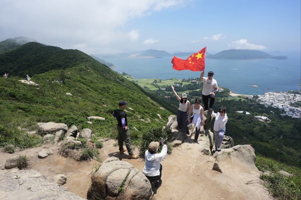 Hikers from mainland China pose for photos at the Dragon’s Back trail in Shek O on Saturday afternoon. Photo: Eugene Lee