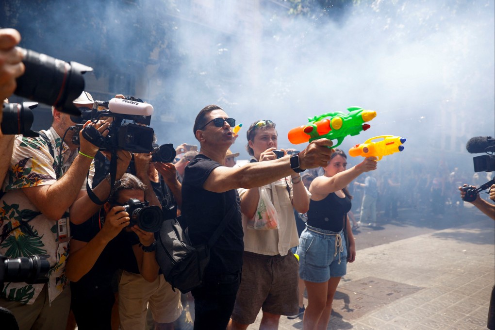 Demonstrators use water pistols during a protest against mass tourism, in Barcelona, Spain, on Sunday. Photo: Reuters