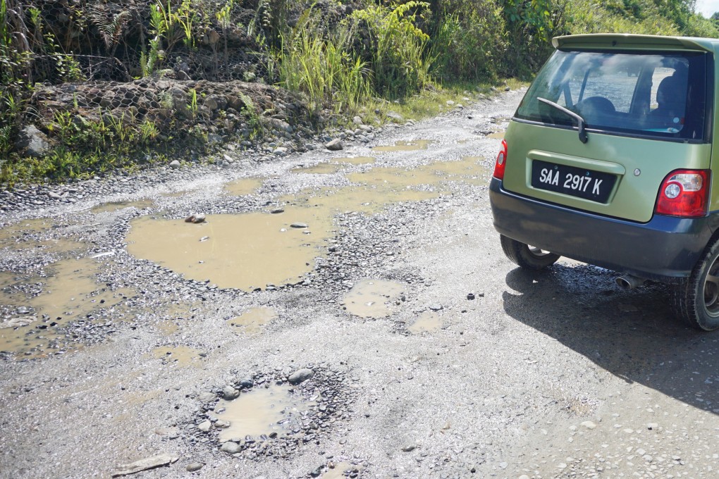 Muddy potholes in middle of a road in rural Sabah, Malaysia. Photo: Shutterstock