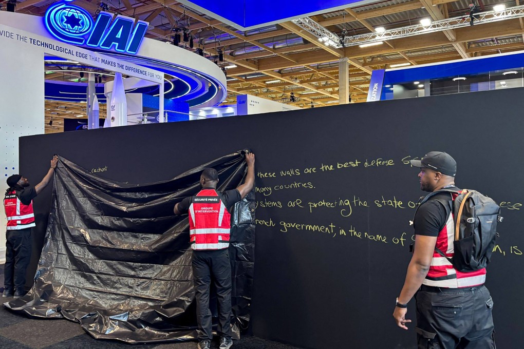 Security personnel work to hide graffiti at the Paris Air Show on Monday, with some stands run by Israel firms blocked off for  showing ‘offensive weapons’. Photo: AFP