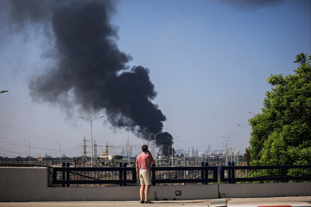 A man looks at smoke in Herzliya, Israel, following a missile attack from Iran on Tuesday. Photo: Reuters