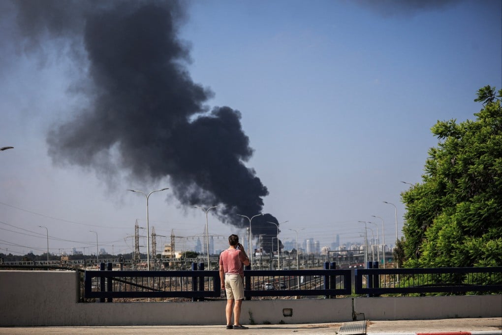 A man looks at smoke in Herzliya, Israel, following a missile attack from Iran on Tuesday. Photo: Reuters
