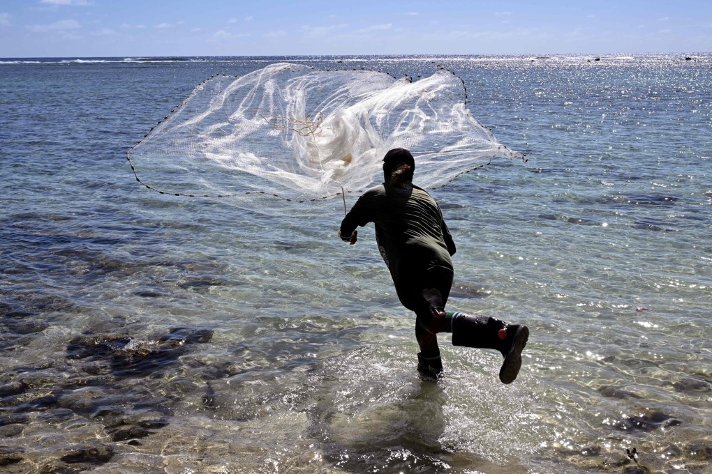 A fisherman casts his net into a lagoon in the Pacific nation of the Cook Islands. The gender gap exists despite women attaining similar education levels as men, the report said. Photo: AFP