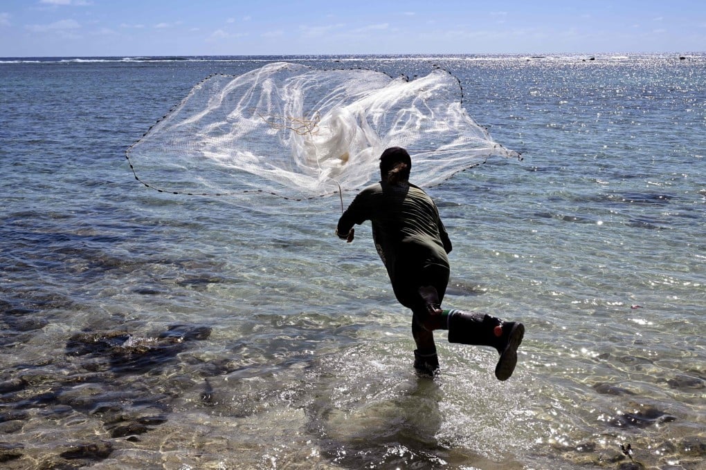 A fisherman casts his net into a lagoon in the Pacific nation of the Cook Islands. The gender gap exists despite women attaining similar education levels as men, the report said. Photo: AFP