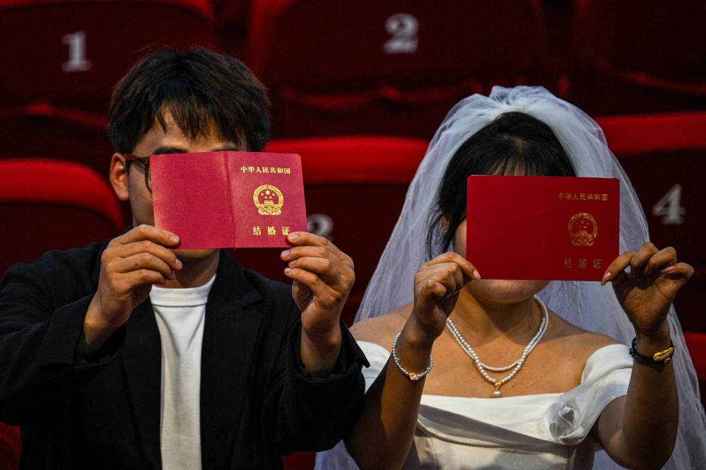 A Chinese couple holds up their marriage certificates. Rising separation rates in China have led to the emergence of divorce appointment booking agents taking advantage of an overwhelmed system. Photo: AFP