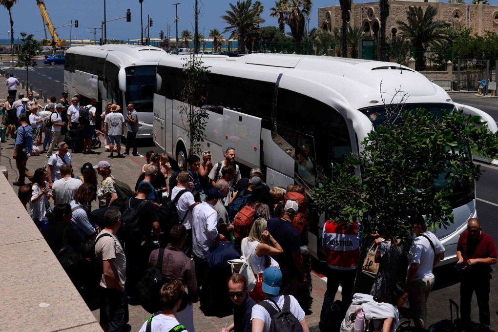 People arrive with their luggage in Tel Aviv before the departure of buses slated to evacuate foreign passport holders out of Israel on Tuesday. Photo: AFP