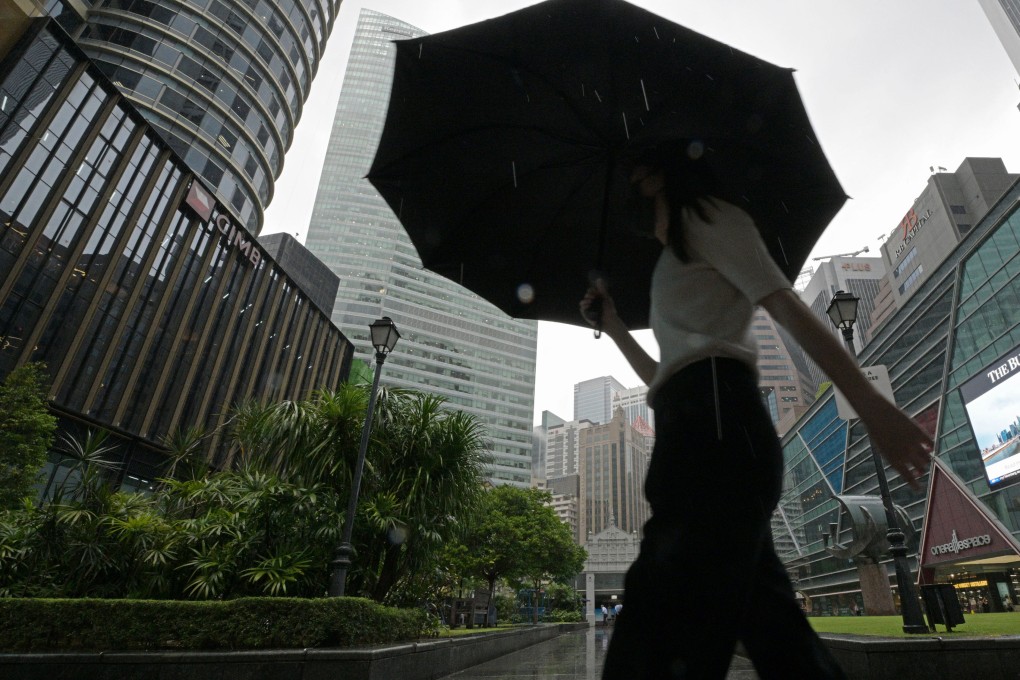 A woman walks in the rain in Singapore’s Raffles Place financial and business district. Photo: Xinhua