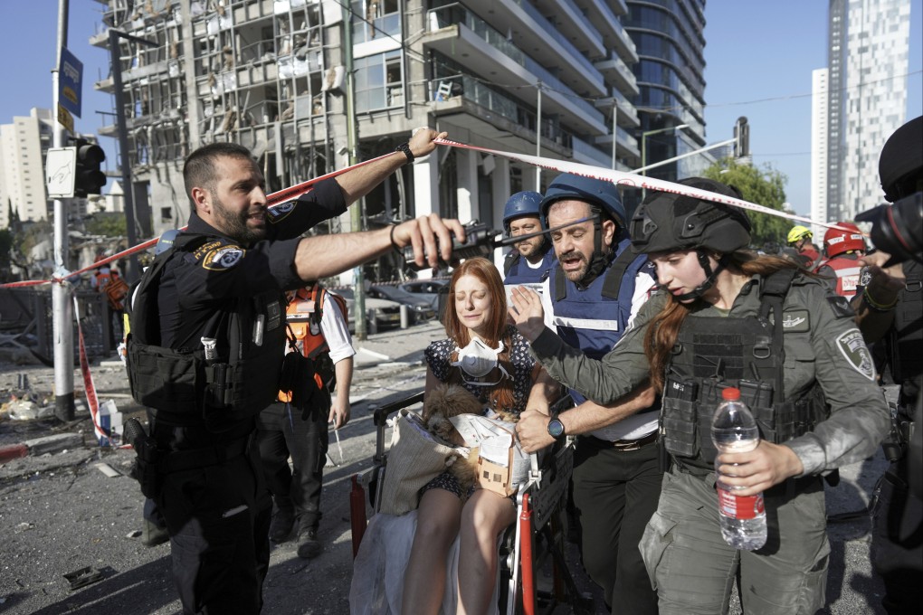 A woman is evacuated from the site of a direct hit from an Iranian missile strike in Ramat Gan, Israel, on Thursday. Photo: AP