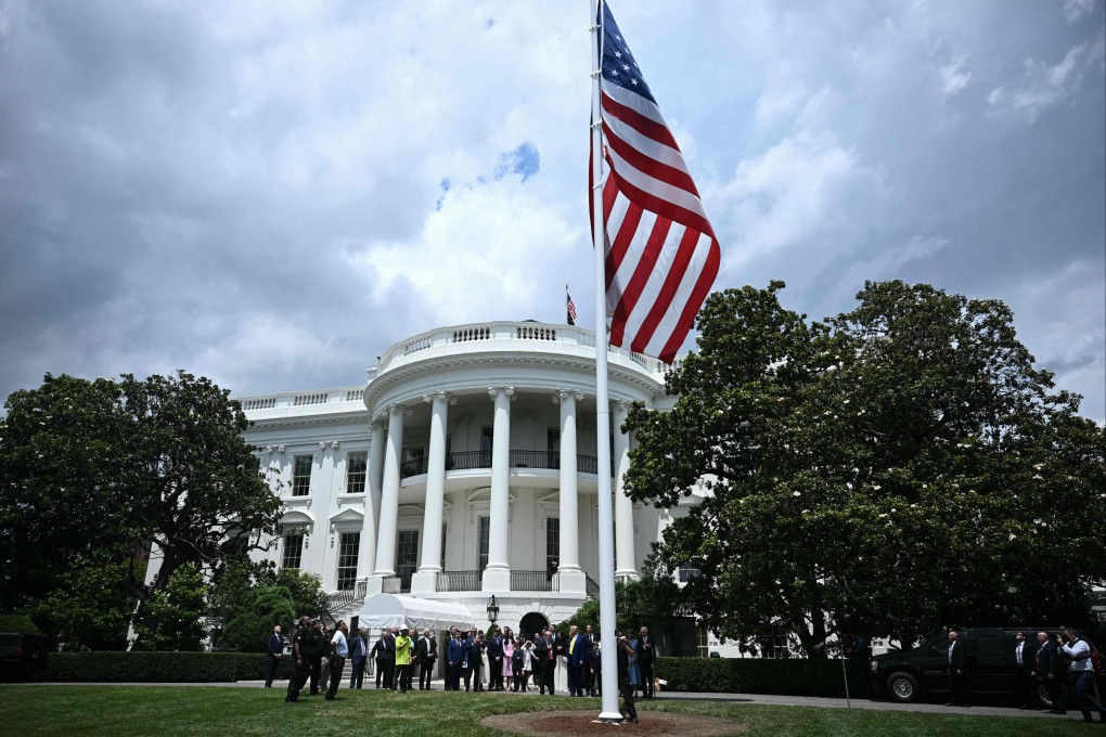 US President Donald Trump looks on as a US flag is raised on a newly installed flagpole on the South Lawn of the White House on Wednesday. Photo: AFP