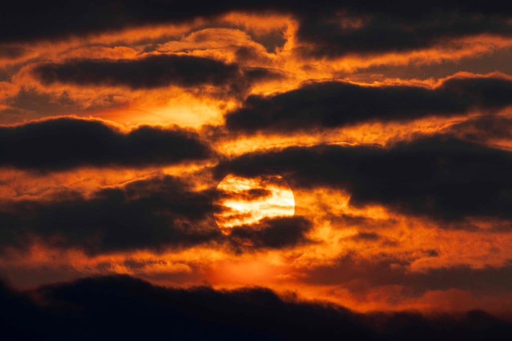TOPSHOT - This photograph shows the sun setting with an orange haze, at sunset in Ablain-Saint-Nazaire, northern France, on June 3, 2025. Large smoke plumes caused by violent and early wildfires in Canada have been hovering over north-western Europe since late May, at very high altitudes without posing health risks, sometimes causing orange sunsets, the European Copernicus observatory stated on June 3, 2025. (Photo by Sameer Al-DOUMY / AFP)