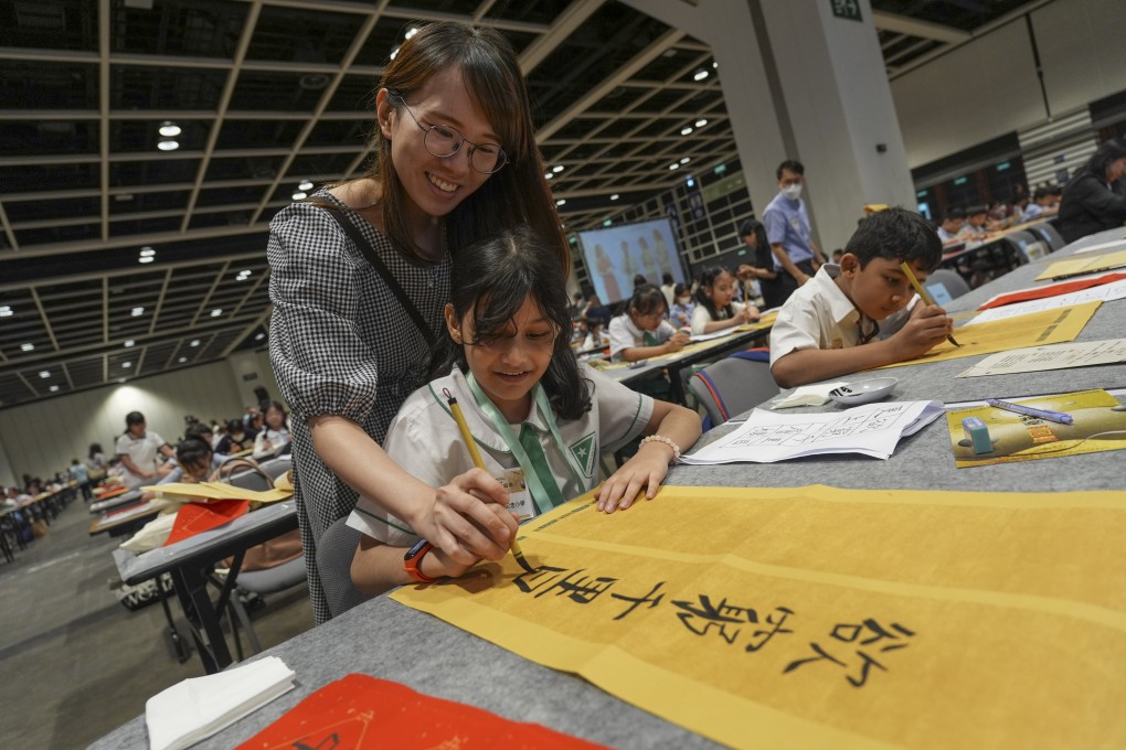 Pupils of Pakistani and Indian origin join a large-scale calligraphy event at Hong Kong Convention and Exhibition Centre in Wan Chai on September 14. Photo: Eugene Lee