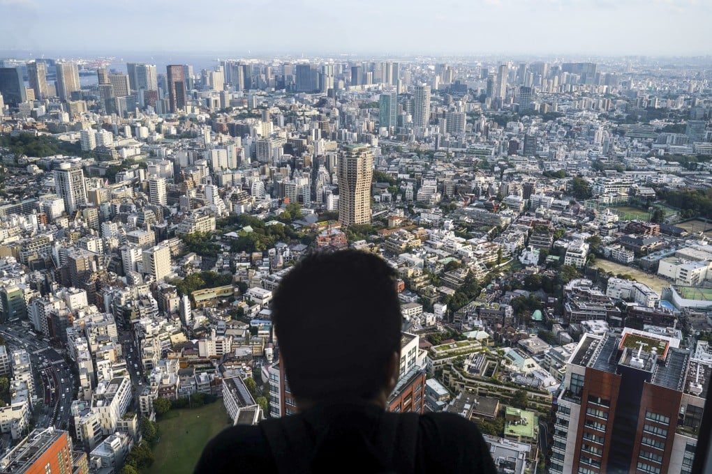 A man watches the cityscape of Tokyo from an observation deck located on the top floor of Roppongi Hills Mori Tower. Photo: AP