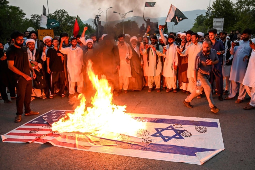 Pakistani activists burn Israeli and US national flags during an anti-Israel protest in Islamabad on Tuesday. Photo: AFP