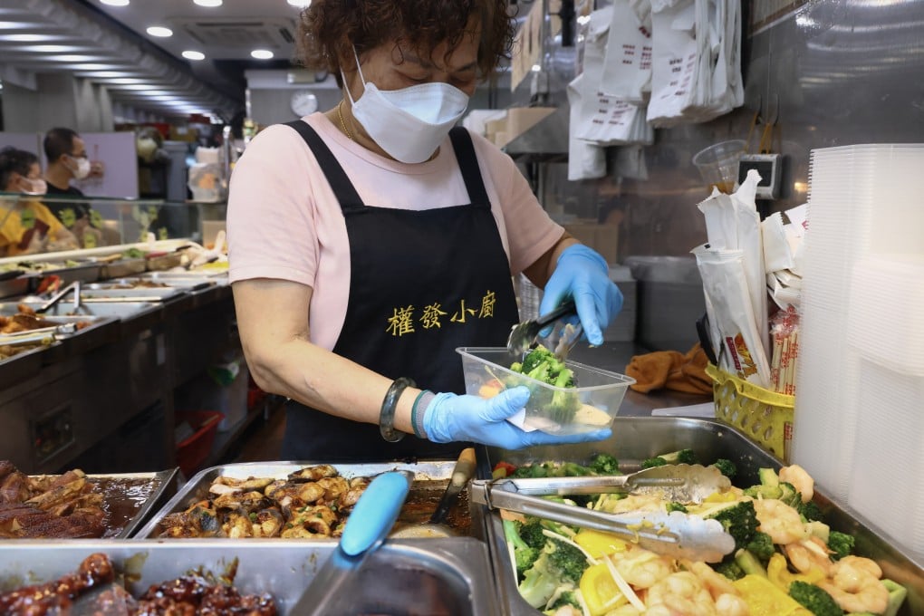 A worker puts food into a container for a customer to take away at a popular “two-dish rice” restaurant in Mong Kok, on May 24. Photo: Dickson Lee