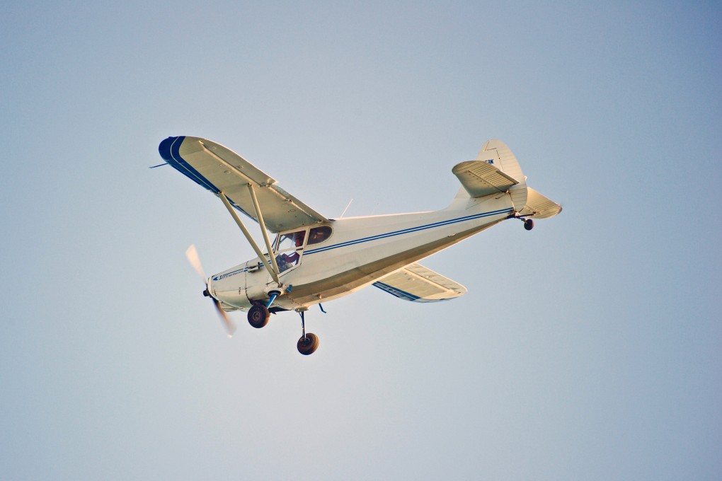 A Universal Stinson 108-2 flies over the Pacific Ocean in Huntington Beach, California, in October 2017. Photo: Shutterstock