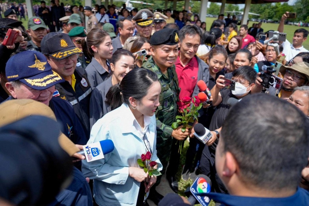 Thailand’s Prime Minister Paetongtarn Shinawatra, accompanied by miltiary officials, receives flowers as she arrives in the border province of Ubon Ratchathani on Friday. Photo: Reuters