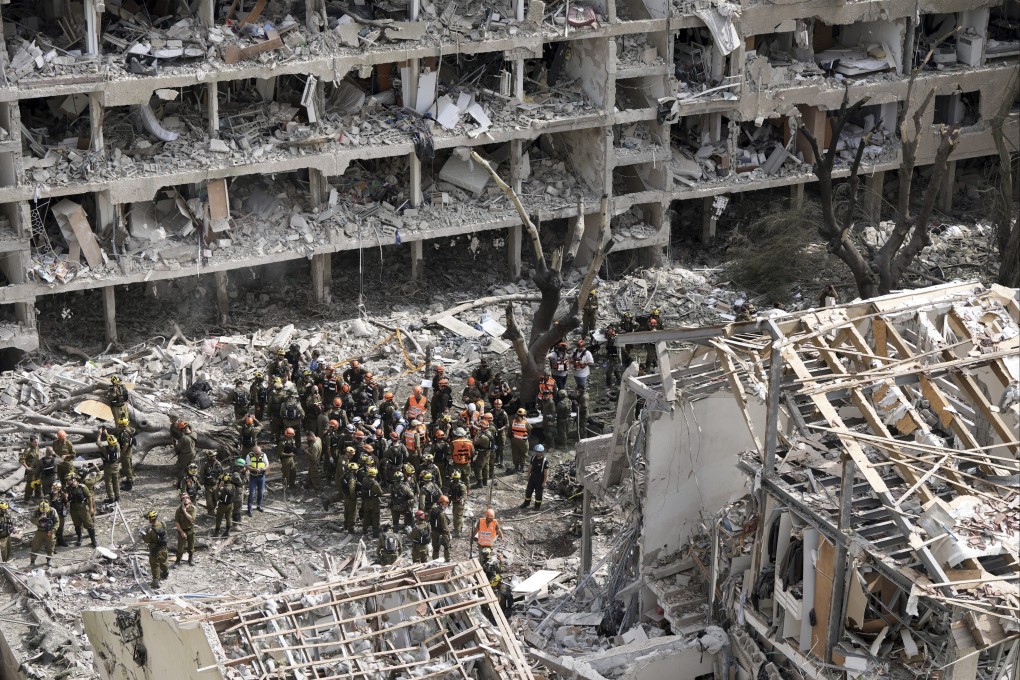 Israeli firefighters and rescuers gather at the site of a missile strike launched from Iran in Tel Aviv on Sunday. Photo: AP